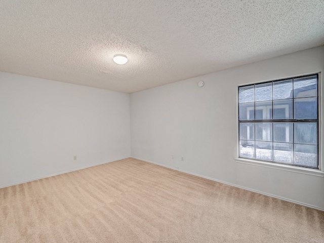 carpeted spare room with a textured ceiling