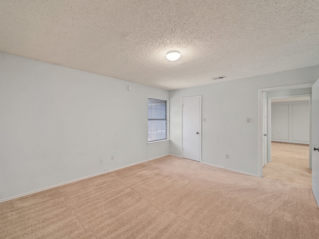 carpeted spare room with a textured ceiling