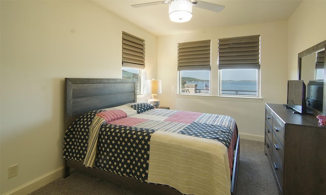 bedroom with dark colored carpet and ceiling fan