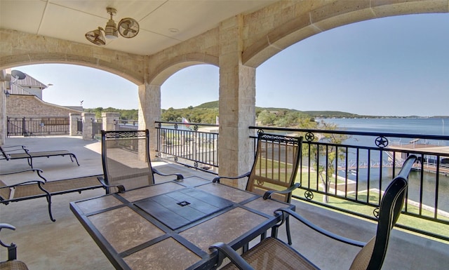 view of patio with a balcony and a water view