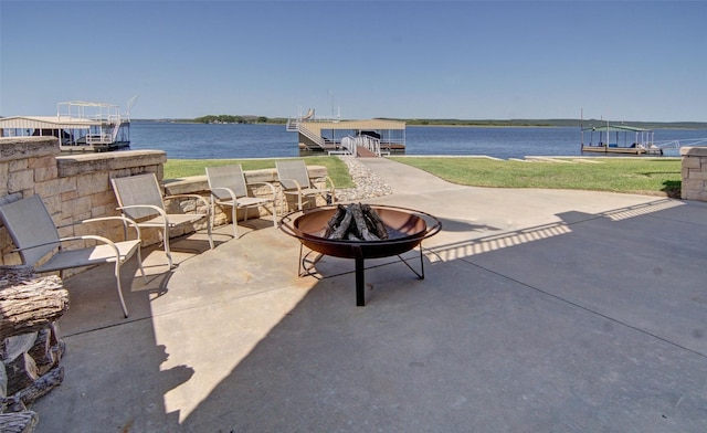 view of patio / terrace featuring a dock, a fire pit, and a water view