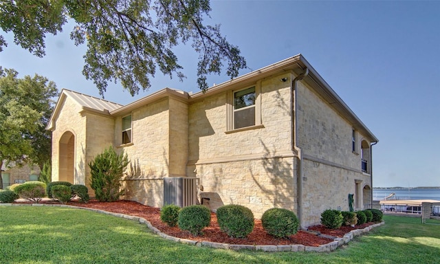 view of home's exterior featuring a lawn and a water view