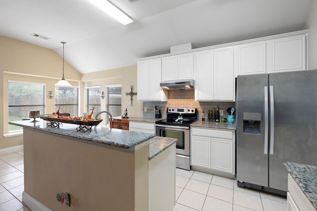 kitchen with light stone counters, white cabinetry, vaulted ceiling, stainless steel appliances, and a center island with sink