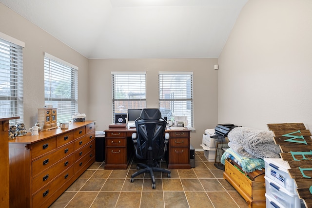 office area featuring lofted ceiling and dark tile patterned flooring