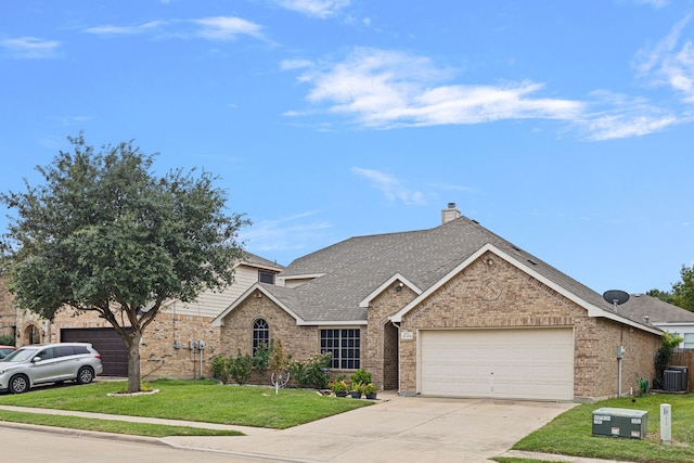 view of front of home with cooling unit, a garage, and a front yard