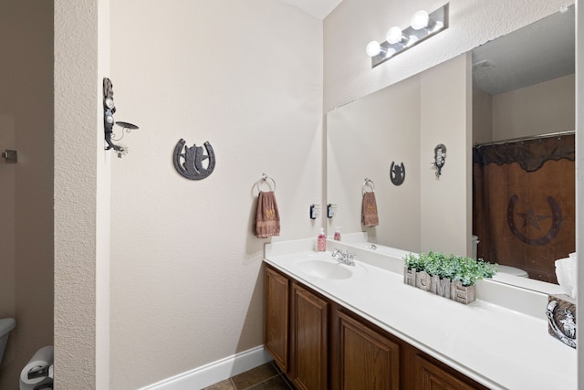 bathroom with tile patterned flooring, vanity, and toilet