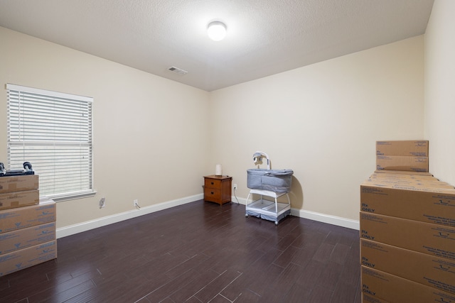 misc room with a textured ceiling and dark wood-type flooring