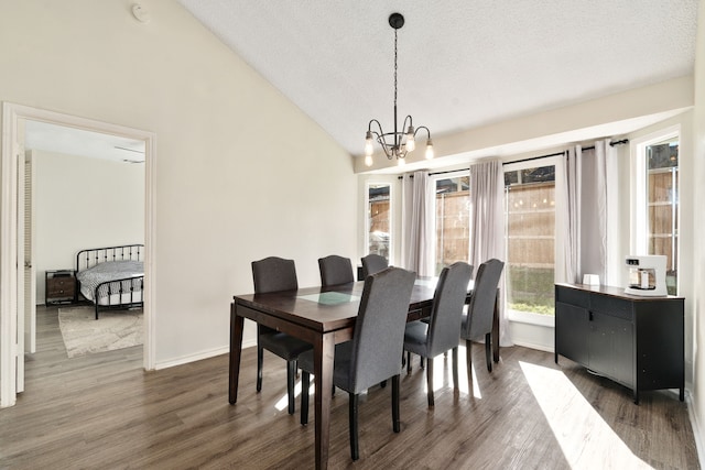 dining area with a notable chandelier, dark hardwood / wood-style floors, and vaulted ceiling