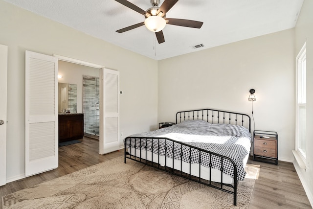 bedroom with ceiling fan, ensuite bathroom, and wood-type flooring