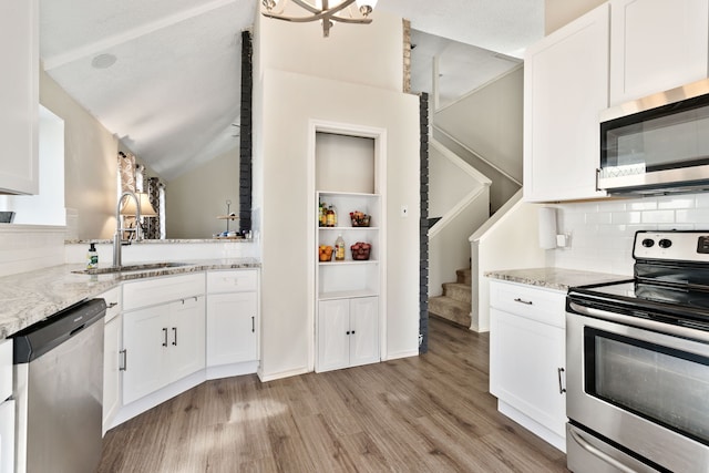 kitchen featuring appliances with stainless steel finishes, white cabinetry, and sink