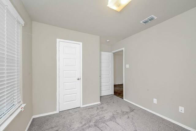 unfurnished bedroom featuring light carpet and a closet