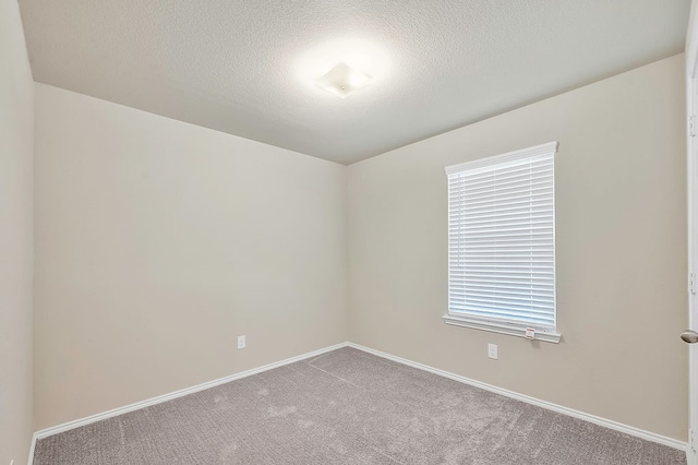 carpeted spare room featuring a textured ceiling