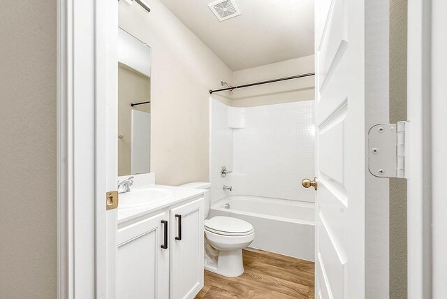 full bathroom with shower / tub combination, hardwood / wood-style flooring, vanity, and toilet