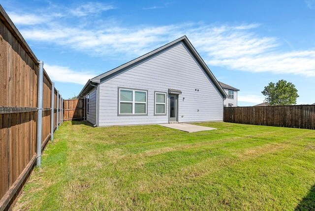 rear view of house with a lawn and a patio