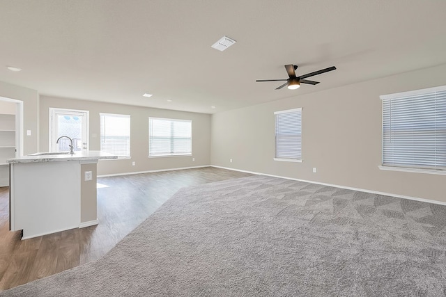 unfurnished living room featuring ceiling fan, dark wood-type flooring, and sink