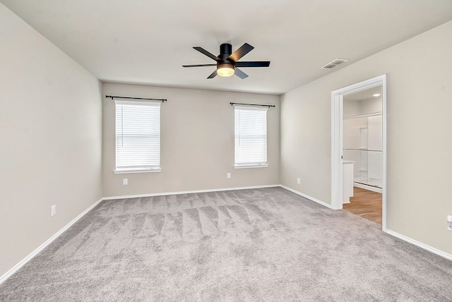 unfurnished bedroom with ceiling fan, light colored carpet, and a spacious closet