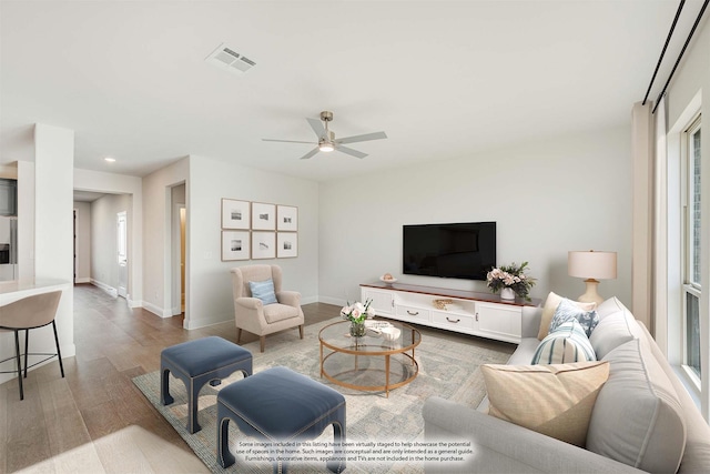 living room featuring ceiling fan and light hardwood / wood-style flooring