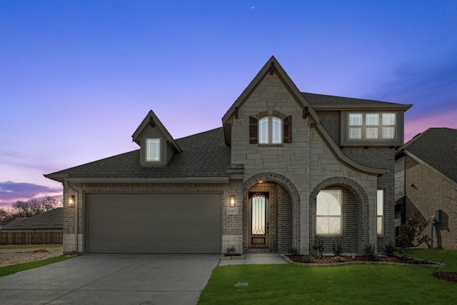 french provincial home with a garage and a yard