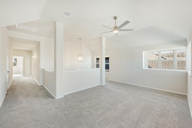 empty room featuring ceiling fan, vaulted ceiling, and light carpet