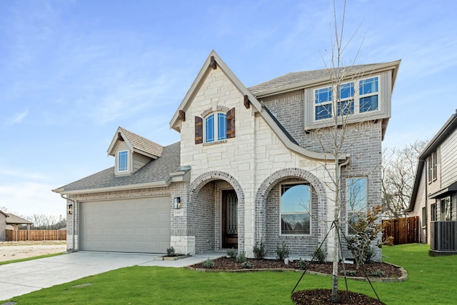 view of front of home featuring a garage, a front lawn, and central air condition unit