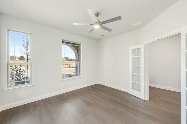 empty room featuring dark wood-type flooring, french doors, and ceiling fan