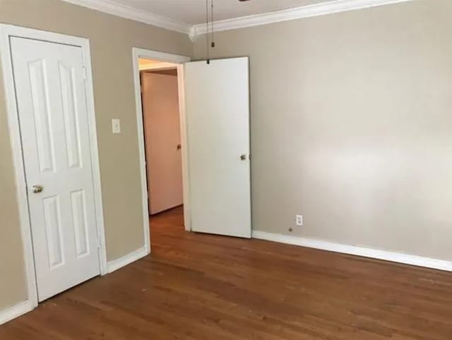 unfurnished bedroom with ornamental molding and dark hardwood / wood-style floors