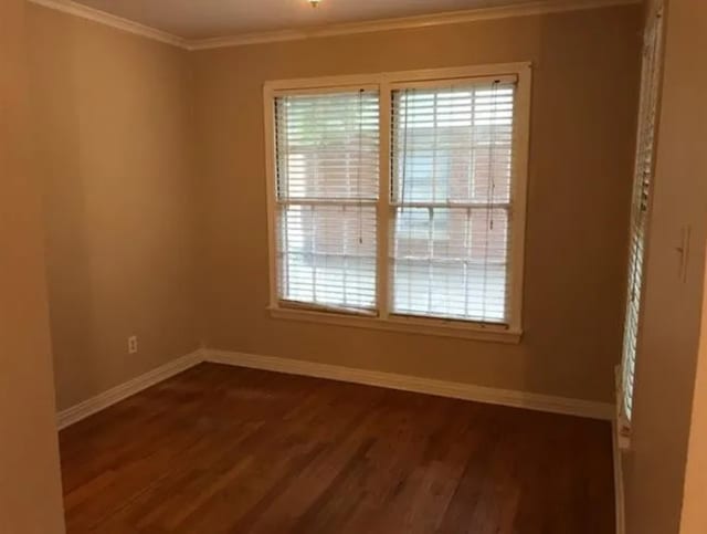 spare room featuring crown molding and dark hardwood / wood-style floors