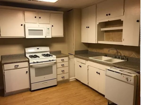 kitchen featuring white cabinets, white appliances, light hardwood / wood-style floors, and sink