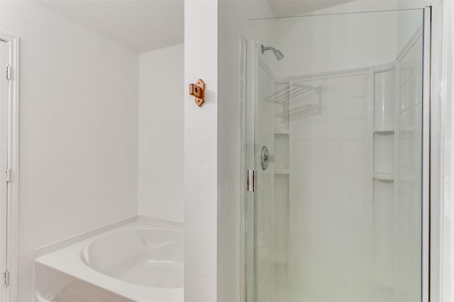 bathroom with independent shower and bath and a textured ceiling