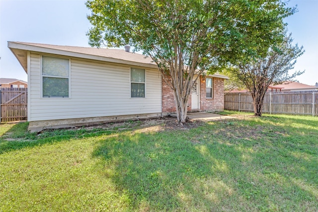 back of house with a lawn