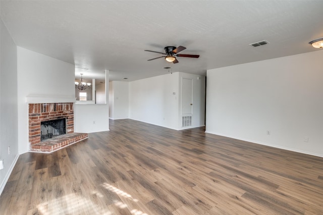 unfurnished living room featuring a fireplace, hardwood / wood-style floors, ceiling fan with notable chandelier, and a textured ceiling