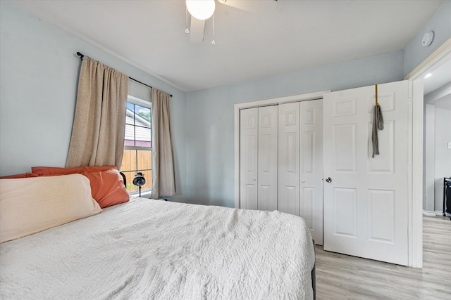 bedroom with light hardwood / wood-style flooring, ceiling fan, and a closet