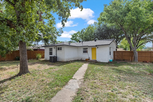 view of front of property with central air condition unit and a front yard