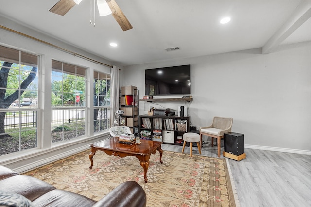 living room with plenty of natural light, ceiling fan, and light wood-type flooring