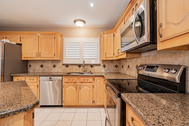 kitchen featuring light stone counters, sink, light brown cabinets, and appliances with stainless steel finishes