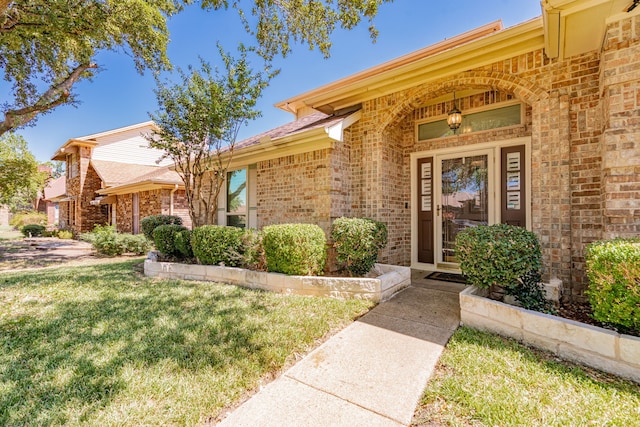 property entrance featuring a lawn and covered porch