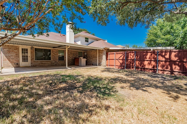 rear view of property featuring a lawn and a patio