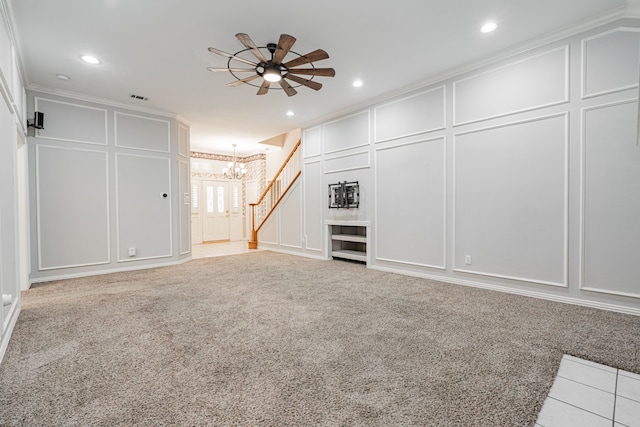 unfurnished living room featuring ceiling fan with notable chandelier, crown molding, and light carpet