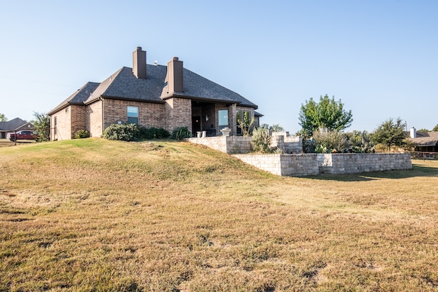 view of side of home featuring a patio area and a lawn