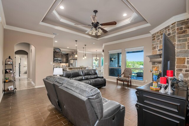 living room with hardwood / wood-style flooring, a raised ceiling, and crown molding