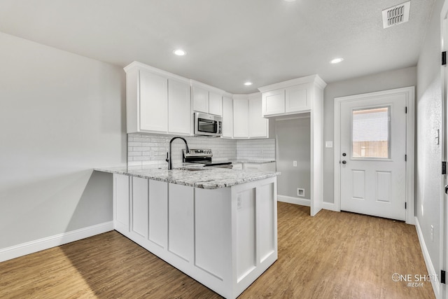 kitchen featuring white cabinetry, stainless steel appliances, light hardwood / wood-style flooring, and sink