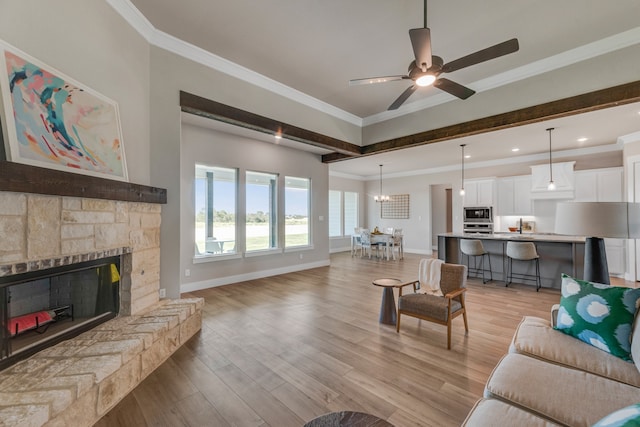 living room featuring ceiling fan, light hardwood / wood-style flooring, a fireplace, and ornamental molding