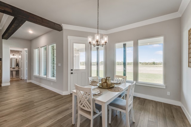 dining room featuring an inviting chandelier, hardwood / wood-style flooring, beam ceiling, and ornamental molding