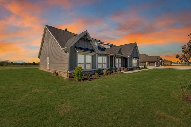 property exterior at dusk featuring a yard