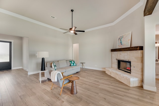 living room featuring light hardwood / wood-style flooring, ornamental molding, ceiling fan, and a fireplace