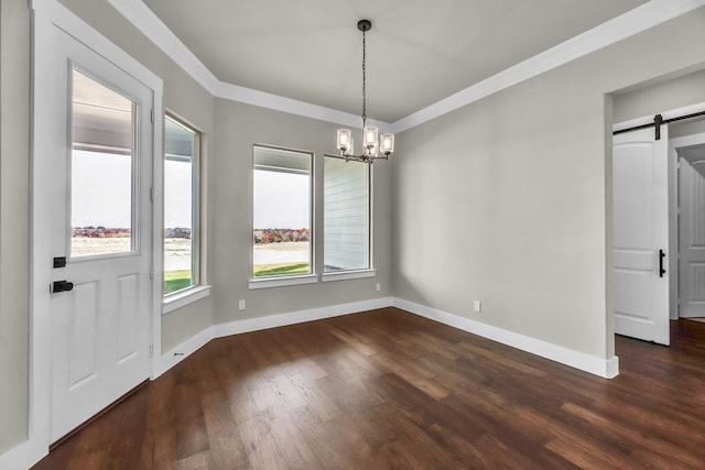 unfurnished dining area featuring a barn door, crown molding, dark hardwood / wood-style floors, and an inviting chandelier