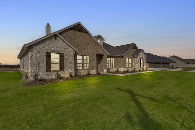 view of front of home with a garage and a yard