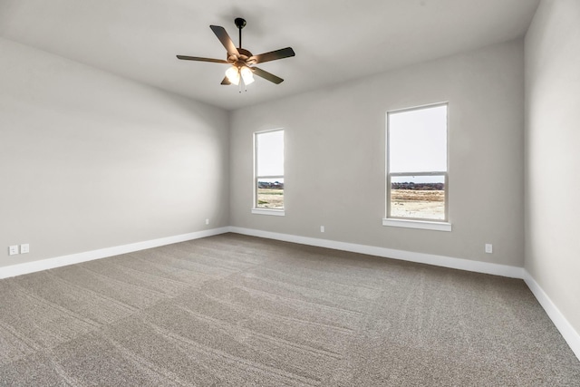 empty room with carpet, a wealth of natural light, and ceiling fan