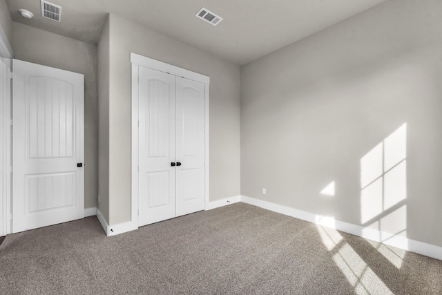 unfurnished bedroom with a closet and dark carpet