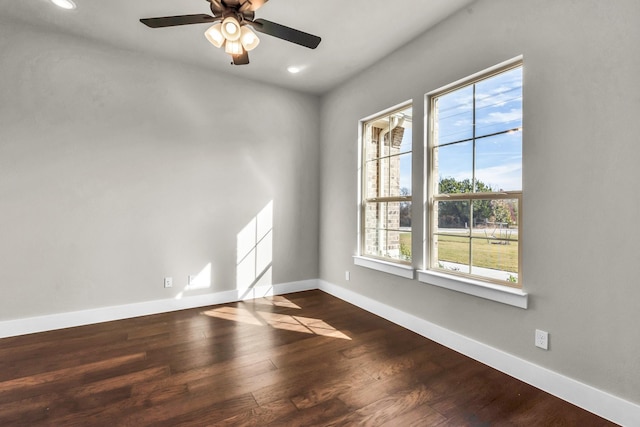 spare room featuring ceiling fan, dark hardwood / wood-style flooring, and a healthy amount of sunlight